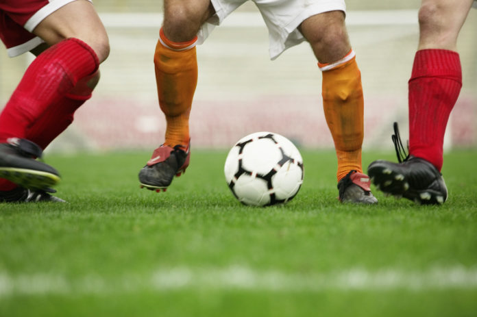 Soccer Player Dribbling Between Defenders