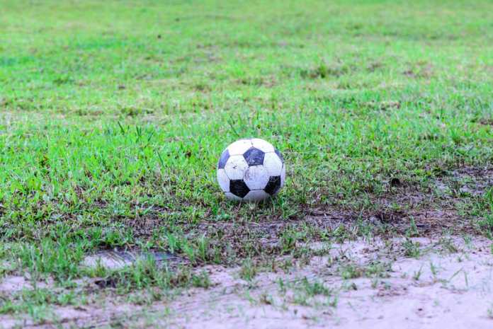 pallone-da-calcio-sporco-nel-campo-bagnato-61154245